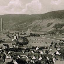 Das Gelände des ehemaligen Reichsschwefelwerks in den 1930er Jahren. Links die beiden Schornsteine und der Wasserturm, im Bildzentrum der Silobau, rechts die Eisenbahnbrücke.